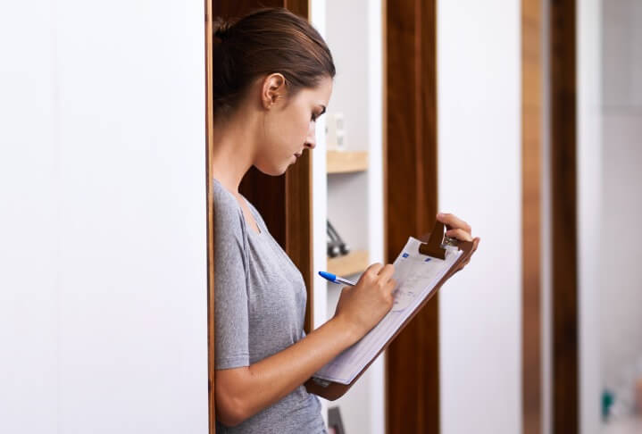 Young woman writing on a clipboard